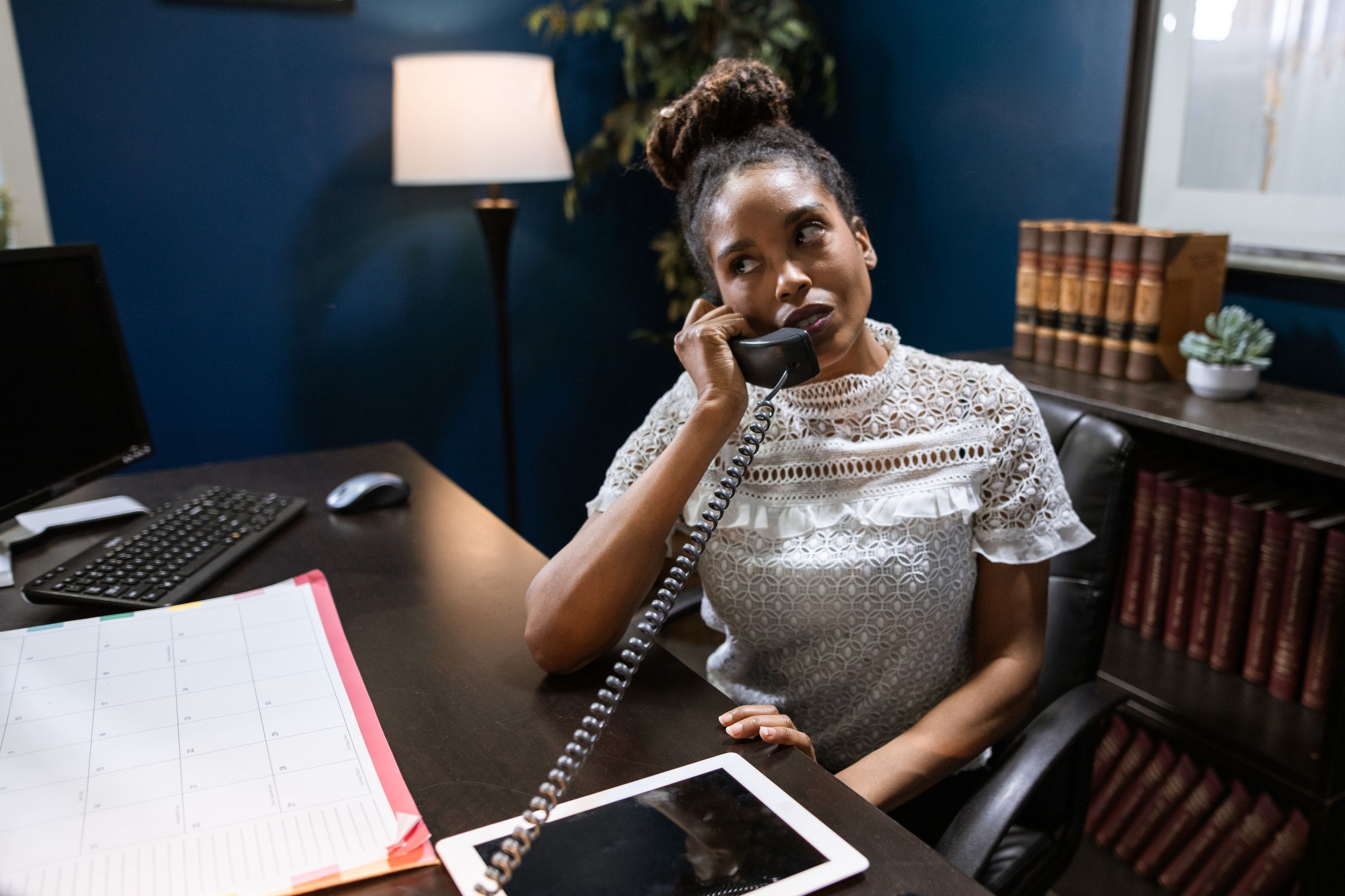 An intake person takes a call at her desk in a small law firm